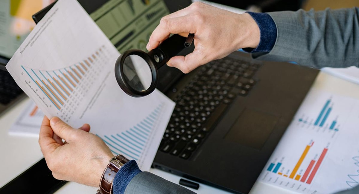 Businessperson analyzing lead generation data with magnifying glass